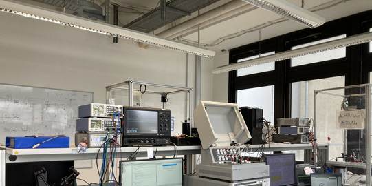 Laborarbeitsplatz - Tisch mit diversen Messgeräten und Computern