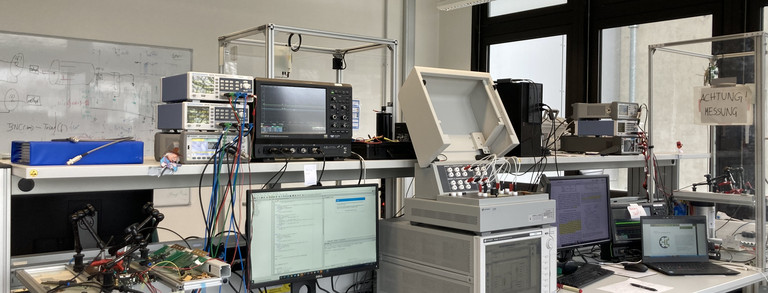 Laborarbeitsplatz - Tisch mit diversen Messgeräten und Computern