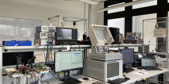 Laborarbeitsplatz - Tisch mit diversen Messgeräten und Computern