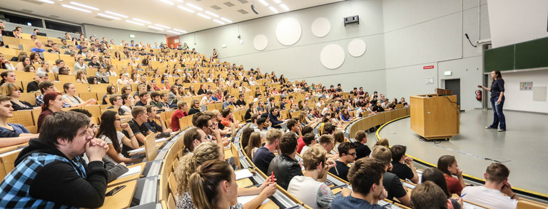 Studierende sitzen in einer Vorlesung im Hörsaal. 